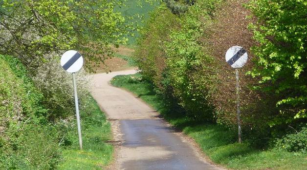 National speed limit signs on narrow country lane, UK